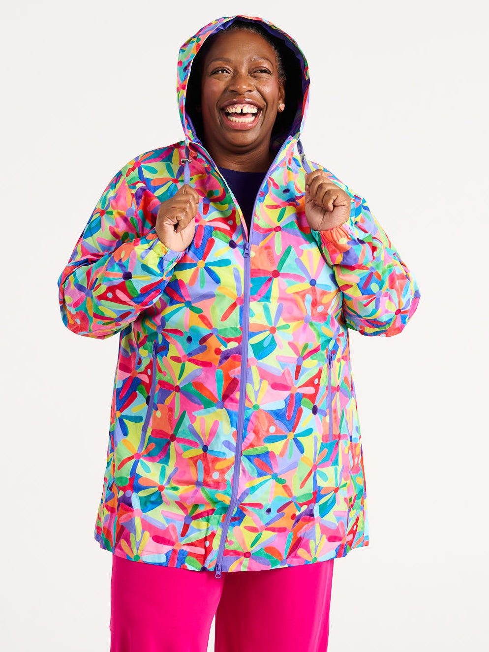 Rainbow Daisies Longline Raincoat - Plus zie Model wearingc olourful waterproof raincoat, worn by Zee