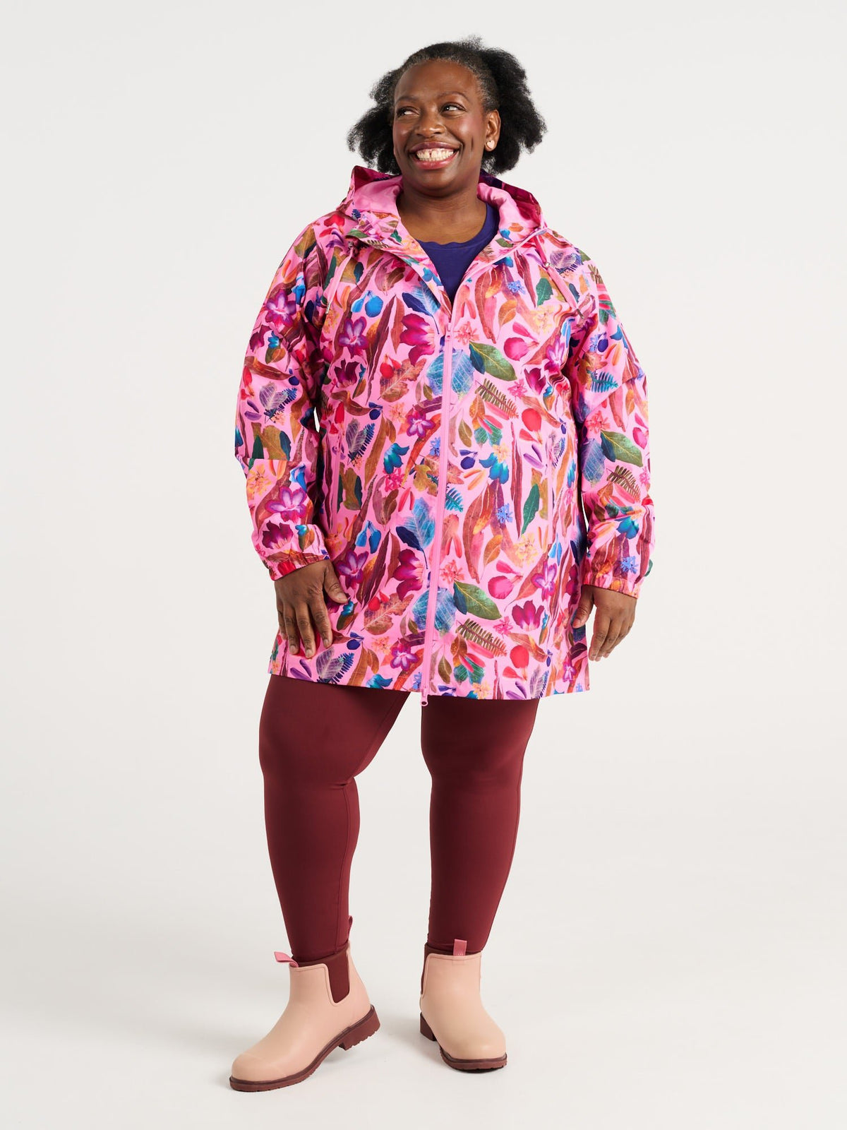 Zee wearing the Backyard Treasures Longline Raincoat in size 3XL, colourful printed waterproof raincoat