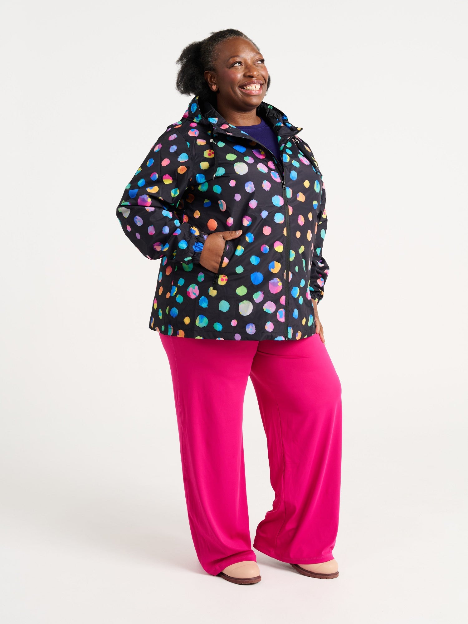 Zee wearing the Night Polka Raincoat in size 3XL, colourful rainbow spotted waterproof raincoat