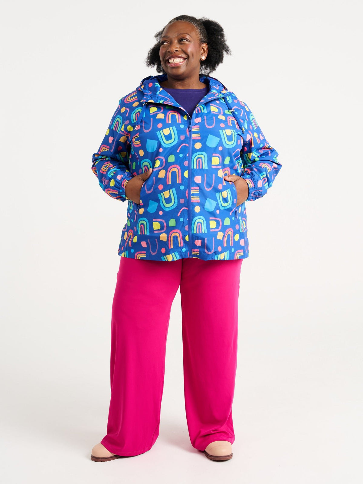 Zee wearing the Rainbow Warrior Raincoat in size 3XL, colourful rainbow printed waterproof raincoat