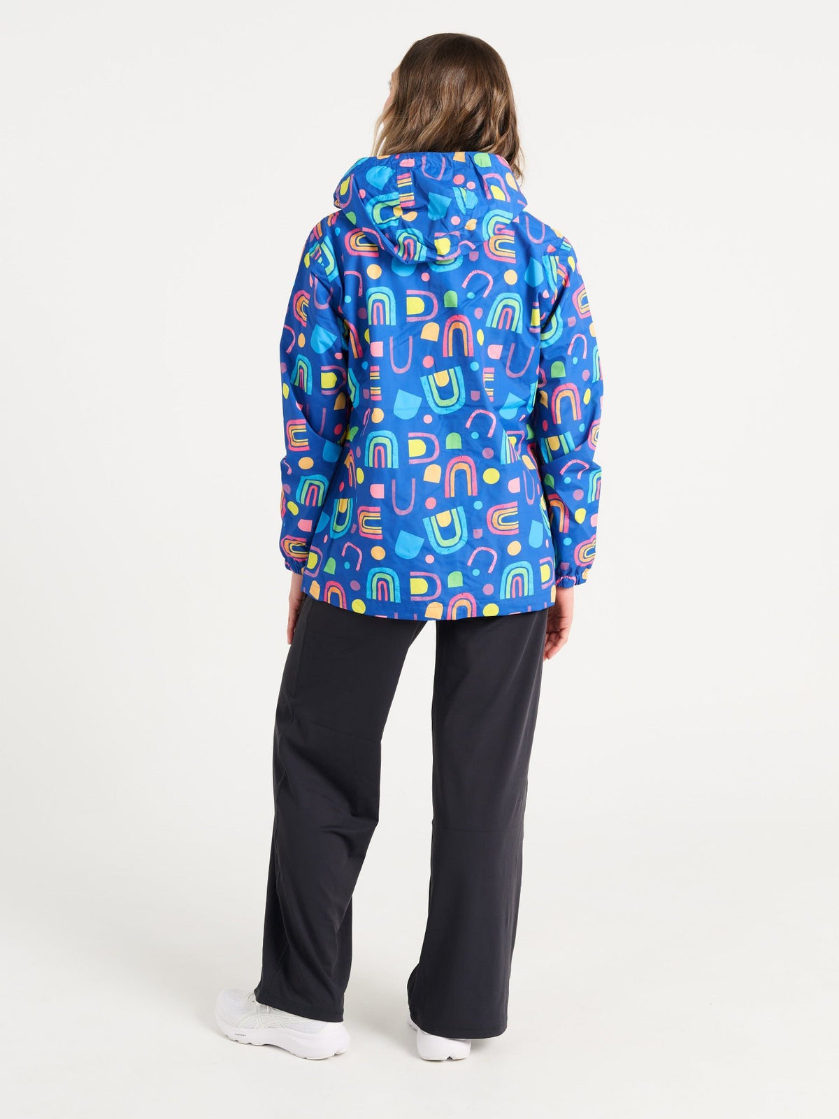 Jennifer wearing the Rainbow Warrior Raincoat in size S, colourful rainbow printed waterproof raincoat