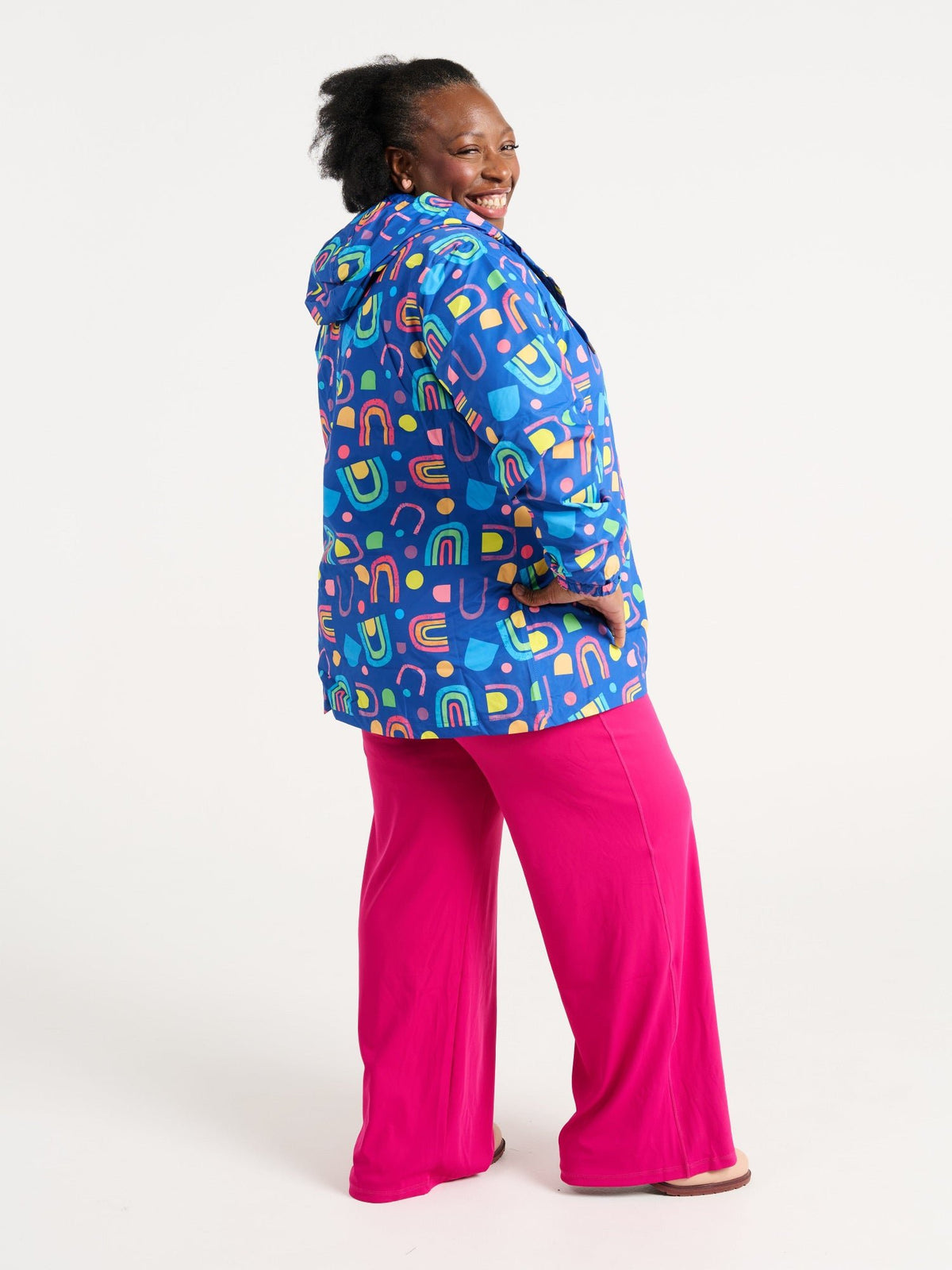Zee wearing the Rainbow Warrior Raincoat in size 3XL, colourful rainbow printed waterproof raincoat