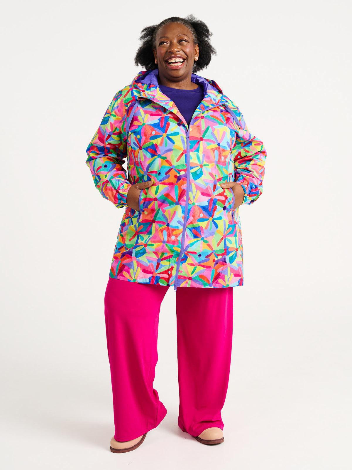 Rainbow Daisies Longline Raincoat - Model wearing daisy print raincoat for wet weather, worn by Zee