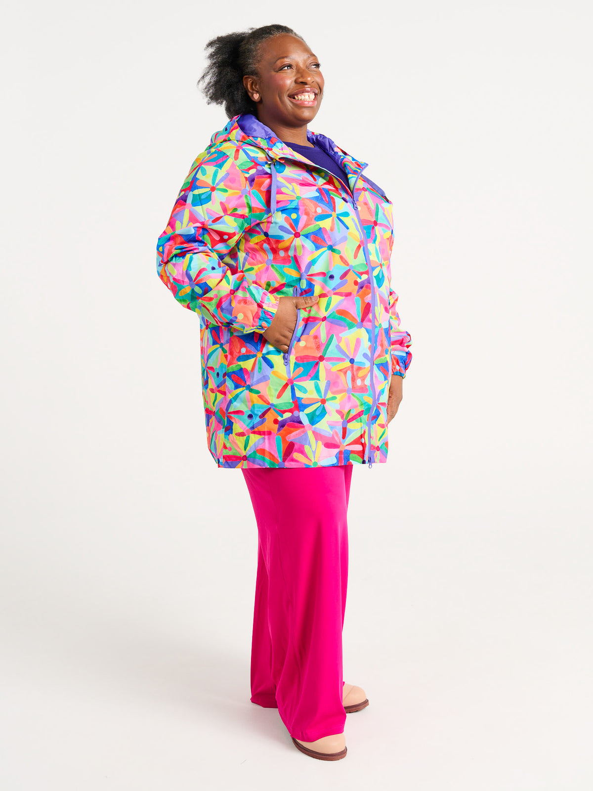 Rainbow Daisies Longline Raincoat - Plus Size Model wearing daisy print raincoat for wet weather, worn by Zee