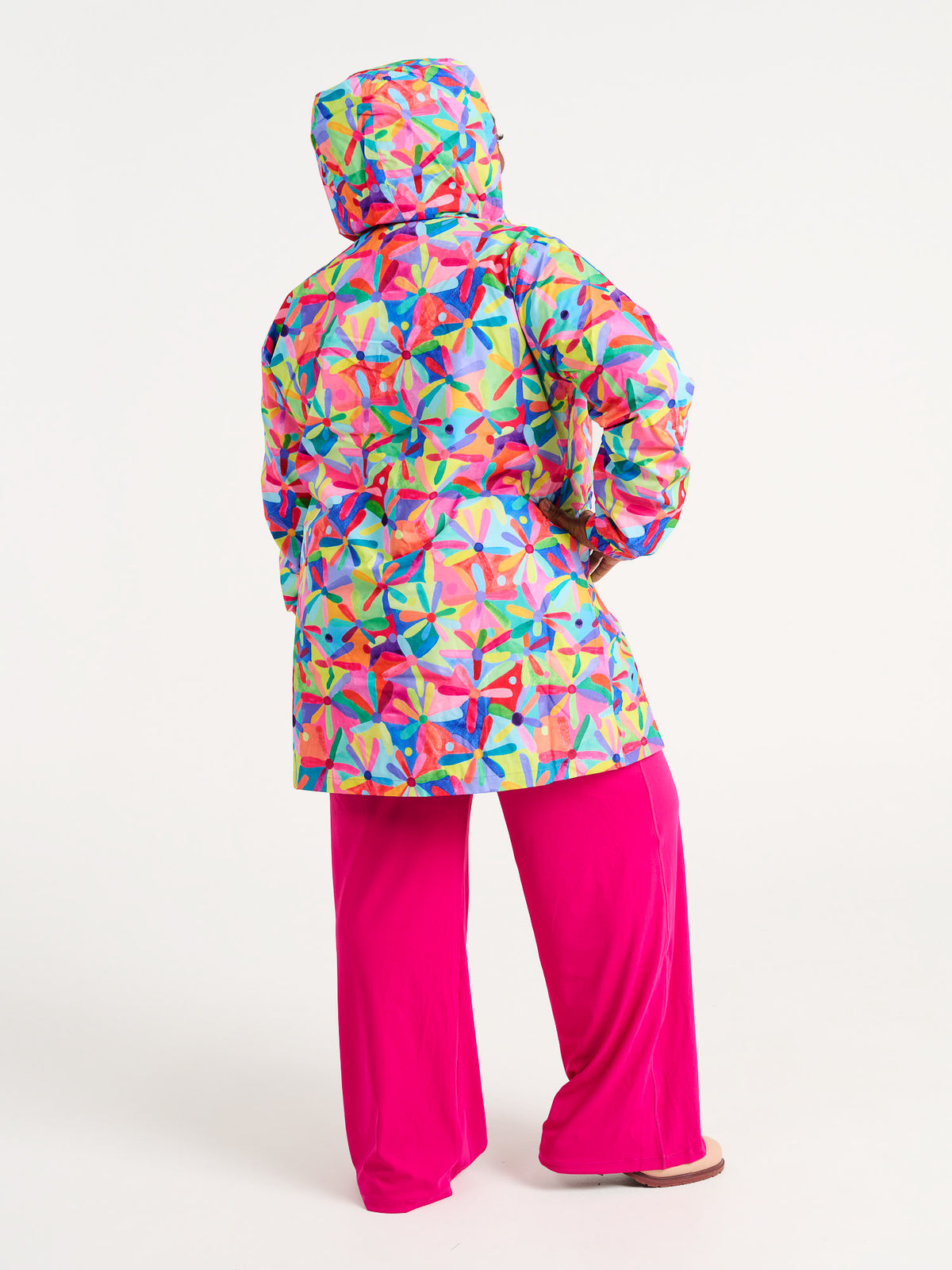 Rainbow Daisies Longline Raincoat - Back of hooded waterproof raincoat, worn by Zee