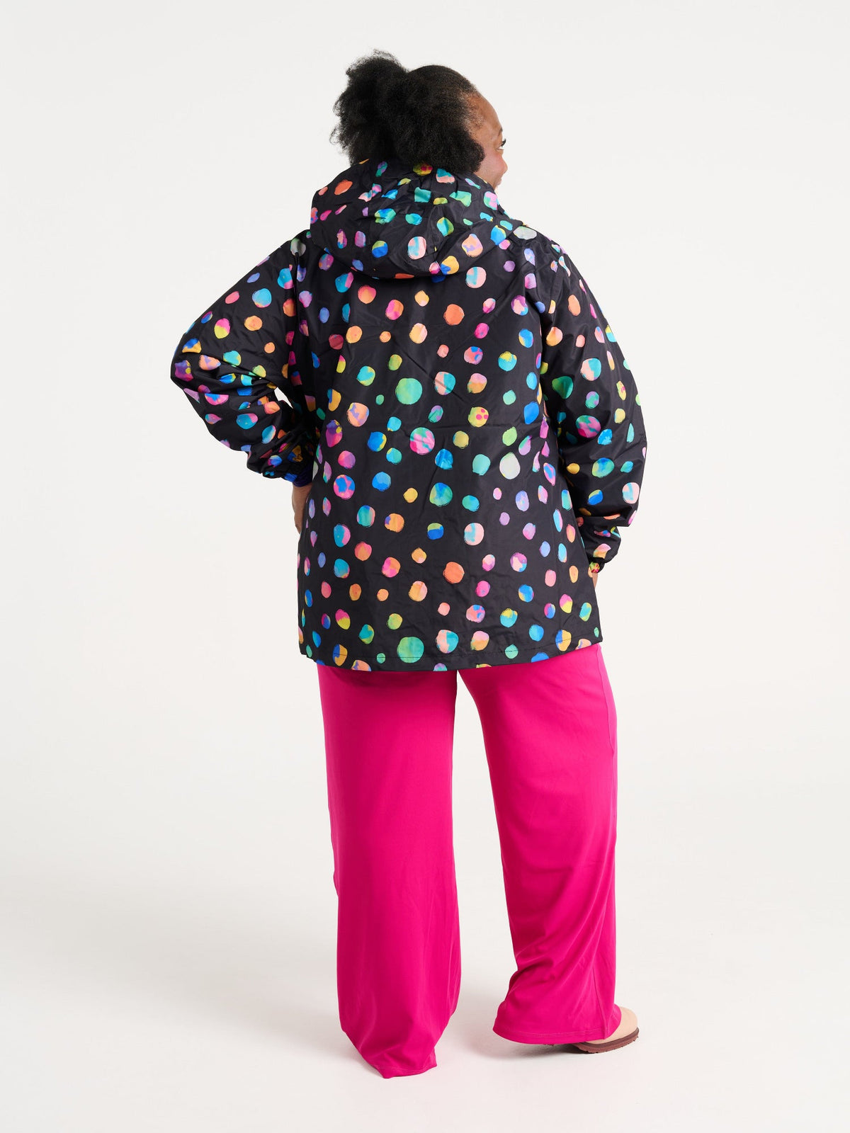 Zee wearing the Night Polka Raincoat in size 3XL, colourful rainbow spotted waterproof raincoat
